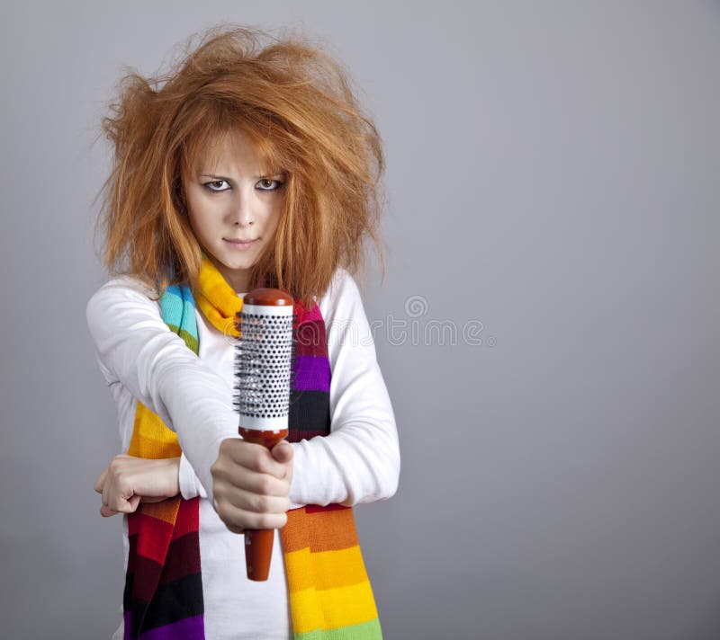 Sad red-haired girl with comb.