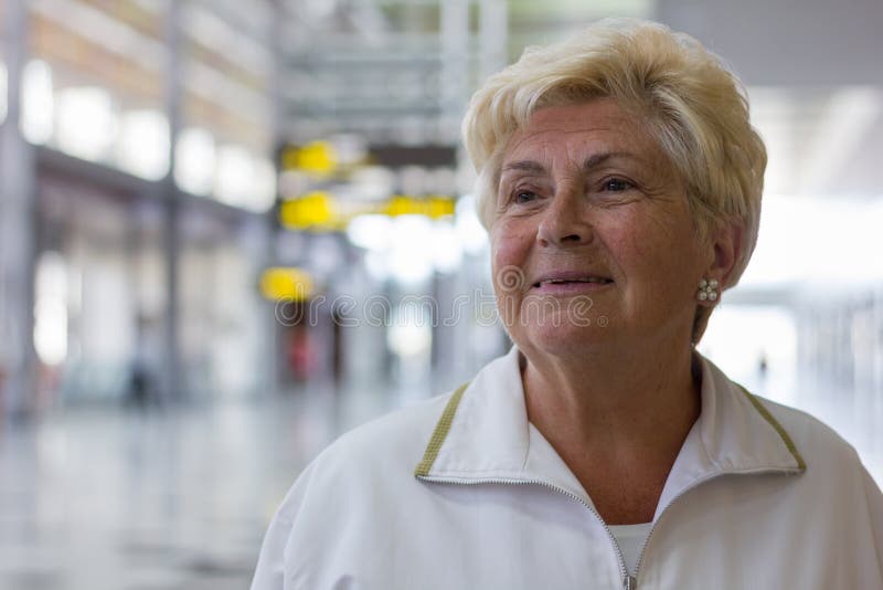 Sad senior woman feeling emotional at airport terminal