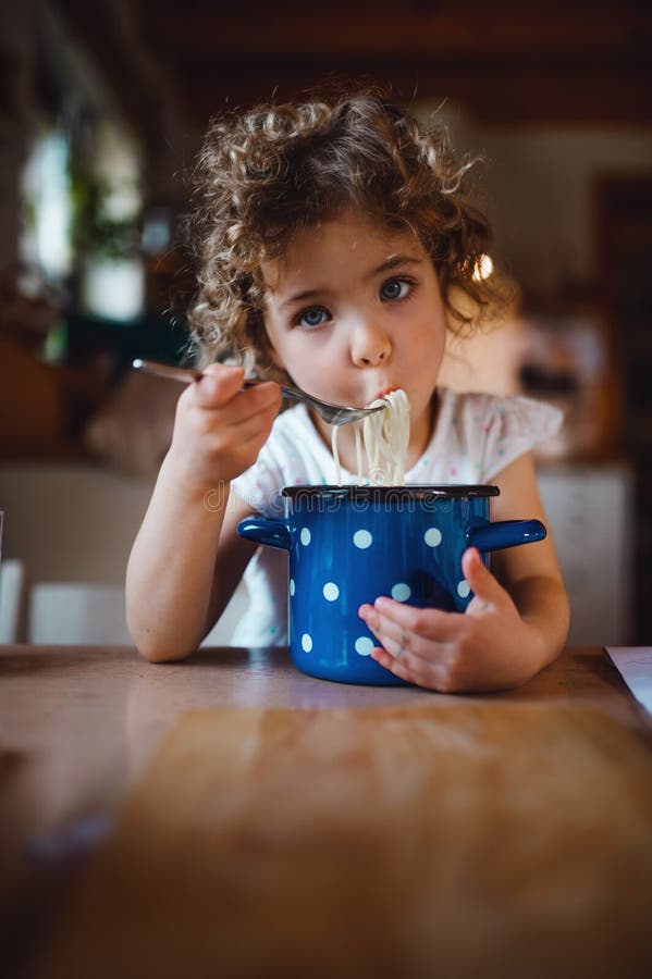 Sad Small Girl Sitting at Table Indoors at Home, Eating Spaghetti ...