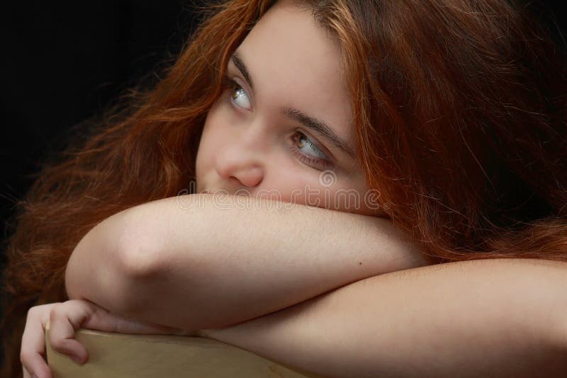 Teen girl depressed sitting in chair with golden eyes. Teen girl depressed sitting in chair with golden eyes