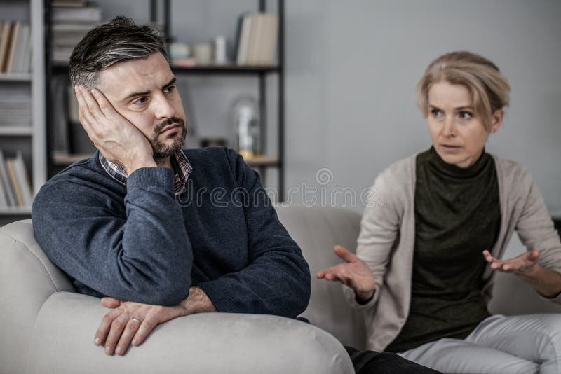 Sad and tired husband in the middle of a fight with a cheating wife