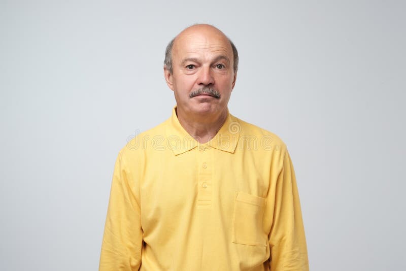 Sad upset mature hispanic guy in yellow pullover looking with guilt and sadness stock image Sad upset mature hispanic guy in yellow pullover looking with guilt and sadness stock image
