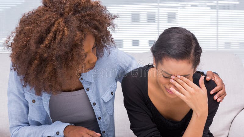 Triste donna che piange accanto a lei terapeuta che è confortante lei.