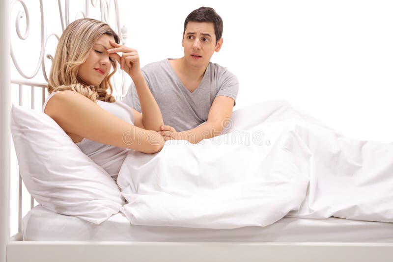 Sad woman lying in bed with a guy comforting her royalty free stock photography Sad woman lying in bed with a guy comforting her royalty free stock photography