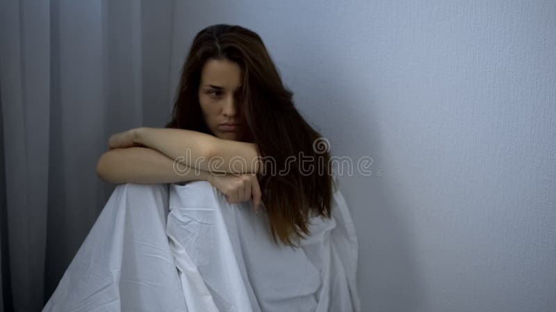 Sad woman with mental illness sitting on floor, hospital patient, depression
