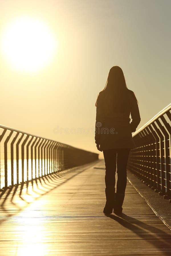 Sad Woman Silhouette  Walking Alone  At Sunset Stock Photo 