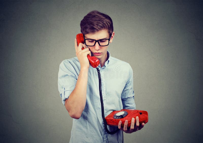 Sad worried teenager man talking on an old fashioned telephone stock photo Sad worried teenager man talking on an old fashioned telephone stock photo