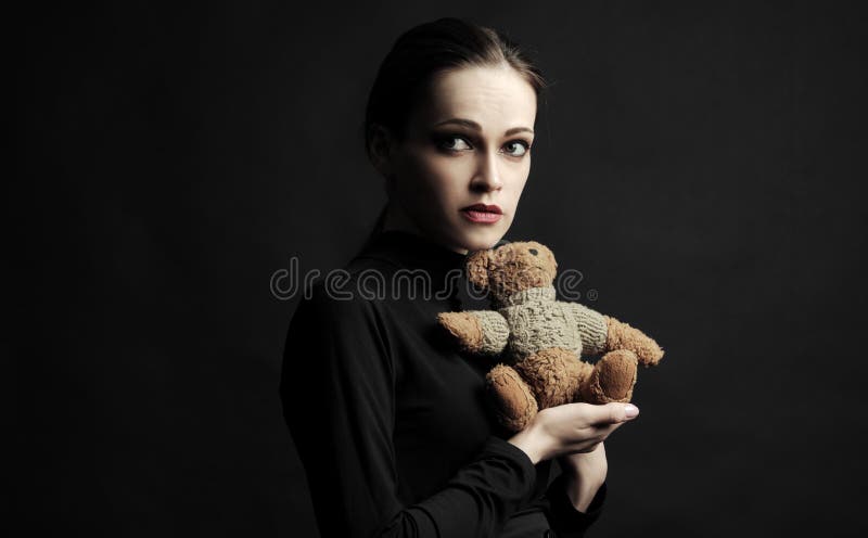 Sad young woman with a teddy bear