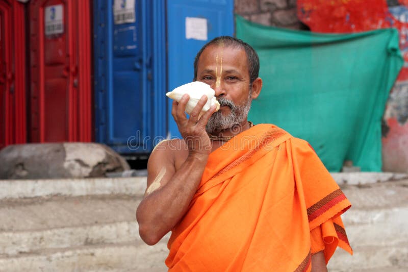 Sadhu holds a white conch royalty free stock photography