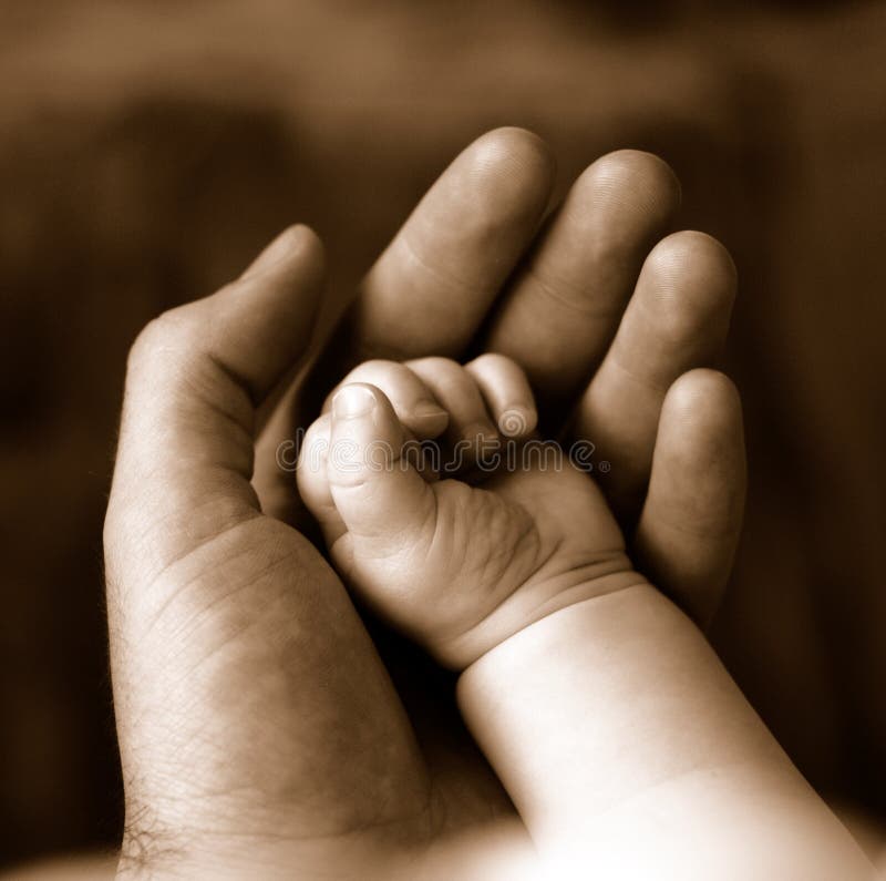 Seppia del padre tenendo la mano di un neonato che dorme.