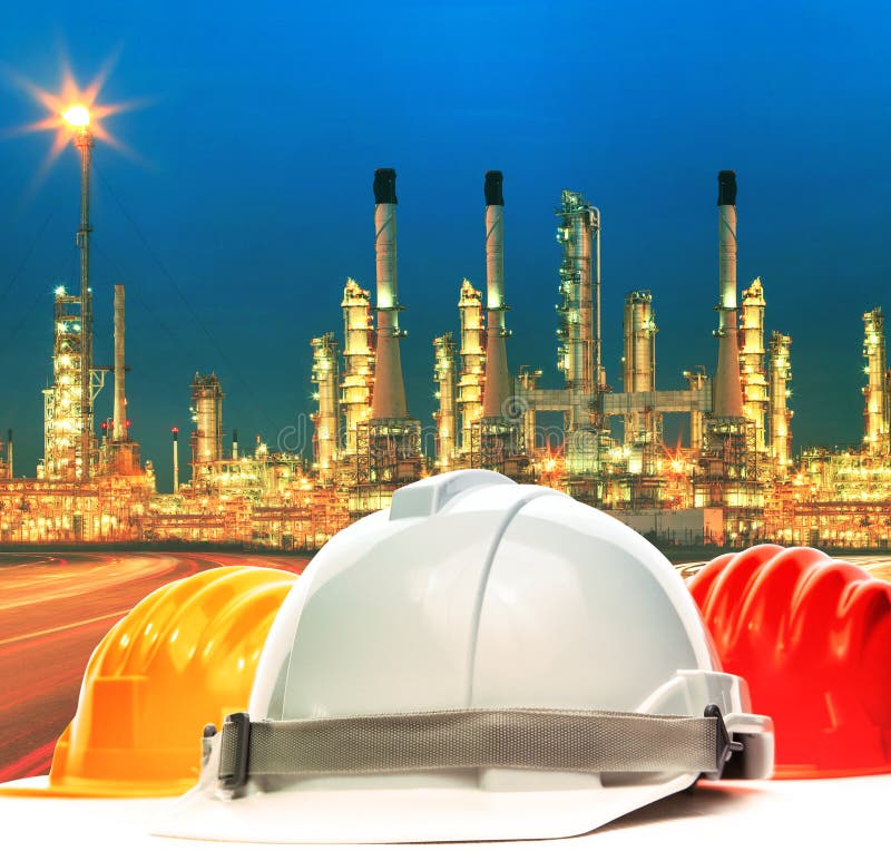 Safety helmet against beautiful lighting of oil refinery plant i stock image