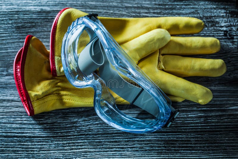 Safety leather gloves glasses on wooden board royalty free stock images Safety leather gloves glasses on wooden board royalty free stock images