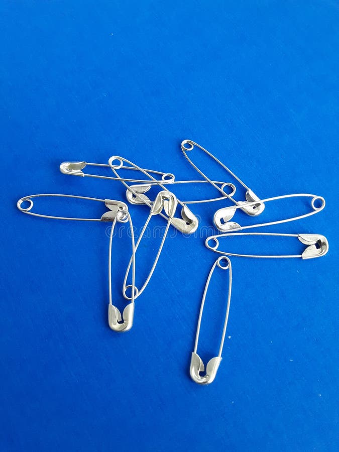 Safety Pins on a Blue Background Stock Photo Image of blue, metal