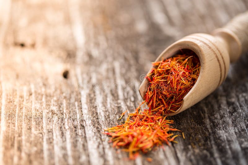 Saffron seasoning in a wooden spoon close up