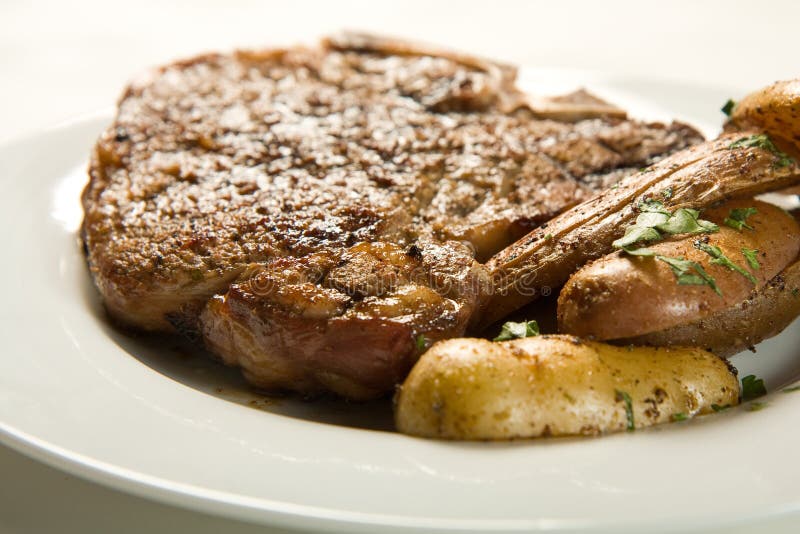 Saftiges Steak Und Kartoffeln Stockbild - Bild von knochen, fett: 6993023
