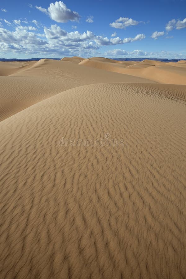 Sahara piaska diuny z chmurnym niebieskim niebem.