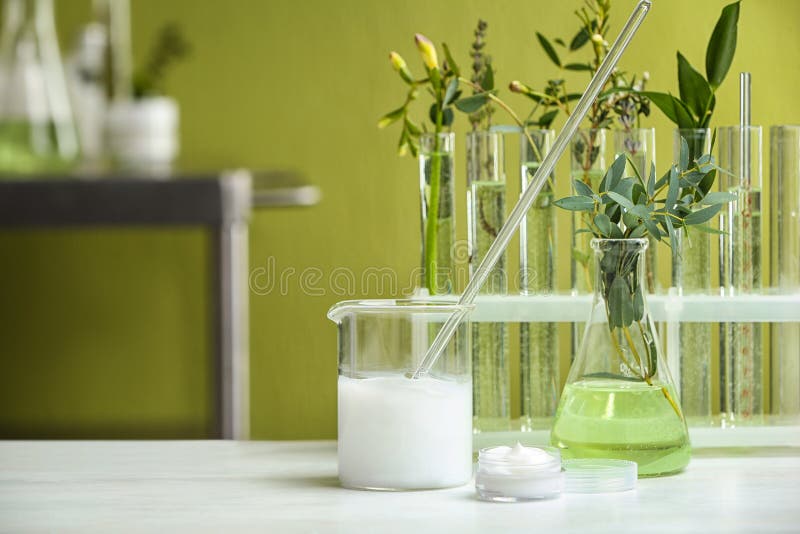 Creme und natürliche Inhaltsstoffe auf weißem Tisch im kosmetischen Labor