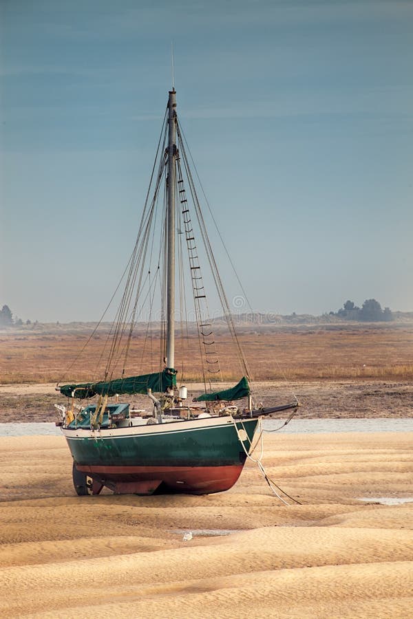 Sail boat stranded at low tide on sand