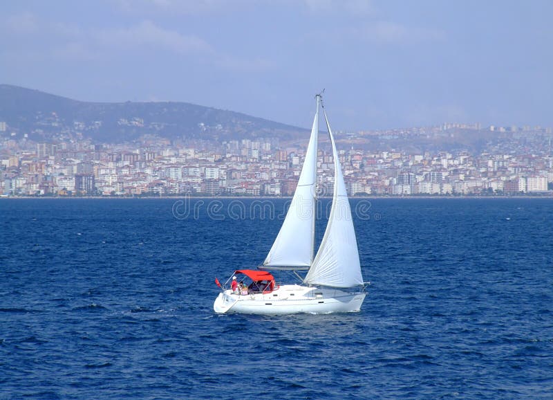 A white sailing boat with the view of an island on the Marmara Sea. A white sailing boat with the view of an island on the Marmara Sea