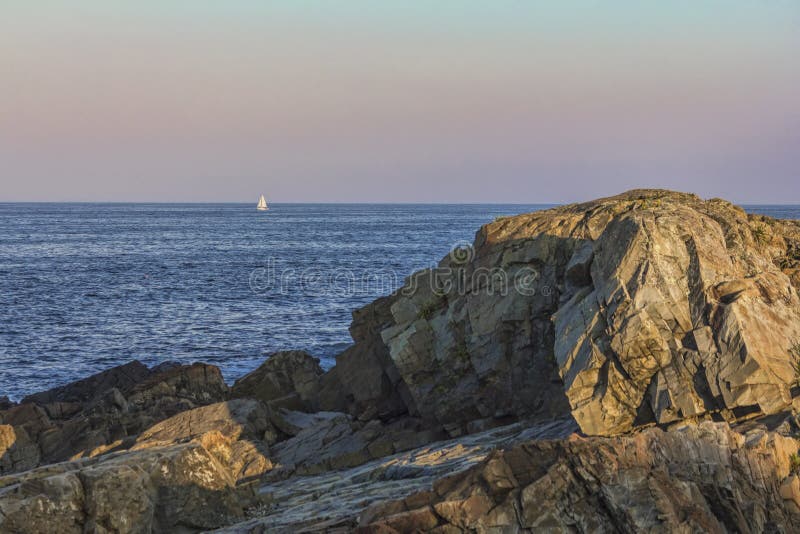 Sailboat Near Ogunquit on the Rocky Coast of Maine at Sunset Stock