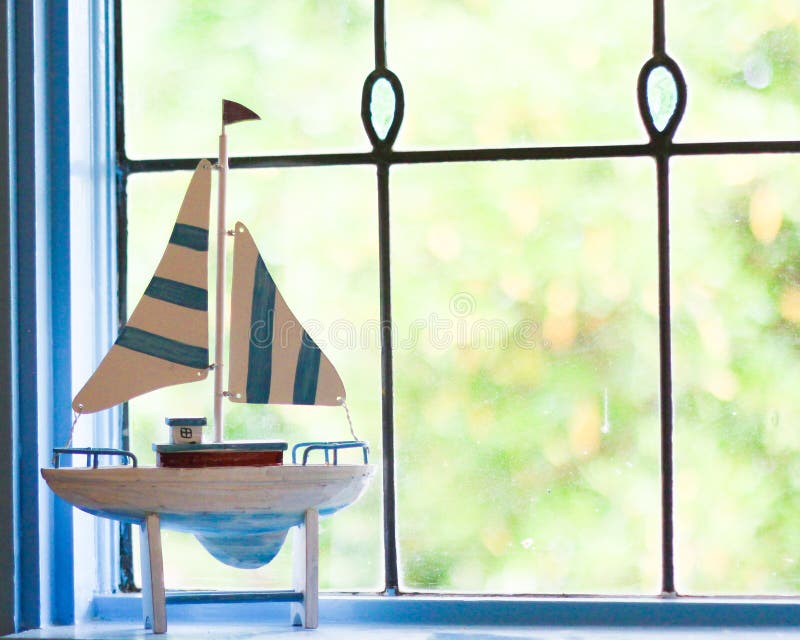 Sailboat ornament in front of lead light window