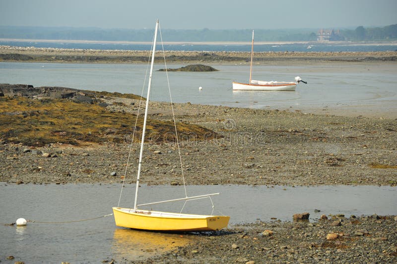 Sailboats laying on rocky beach at low tide