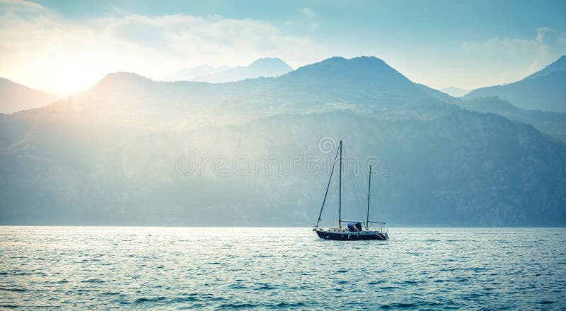 Sailer boat sailing by sea waves in evening