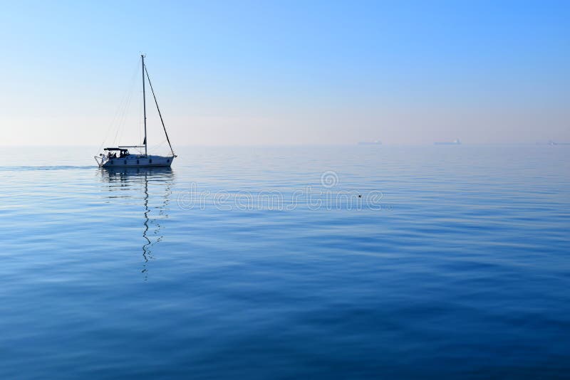 Sailing boat in Thermaikos Gulf, Thessaloniki Greece. Foggy blue seascape