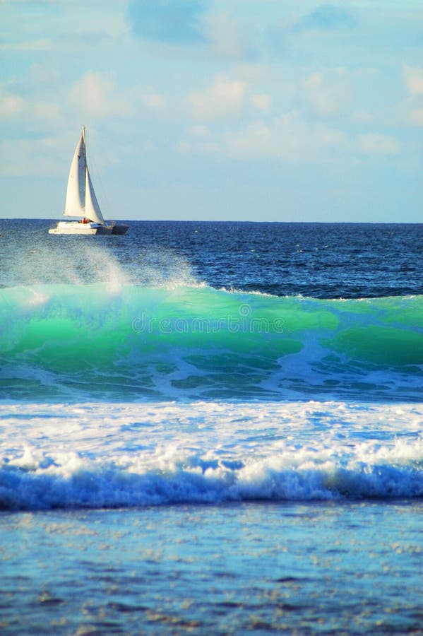 Barca a vela lungo la costa del Tramonto Spiaggia di Oahu, nelle Hawaii.