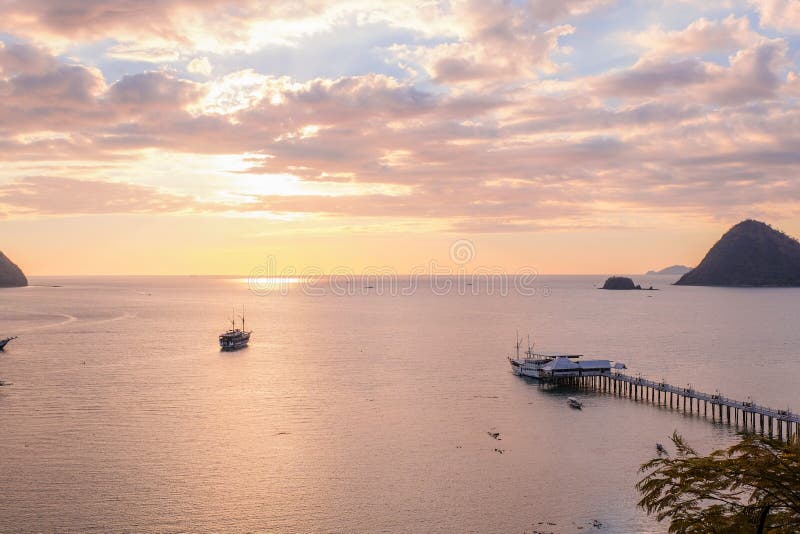 Sailing boats and marina of Labuan Bajo coast and a marina with pink sky background during sunset