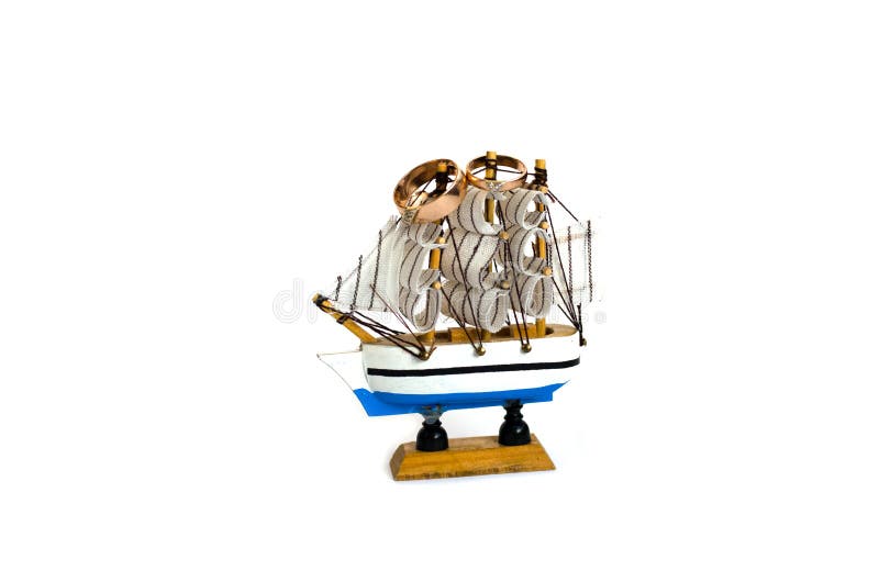 Sailing ship model with wedding rings isolated on white background royalty free stock photography Sailing ship model with wedding rings isolated on white background royalty free stock photography