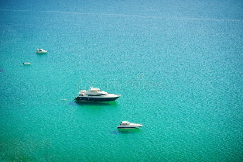 Aerial view of sea and yacht. Sailing ship in the middle of ocean, top view, summer background. Amazing view to Yacht