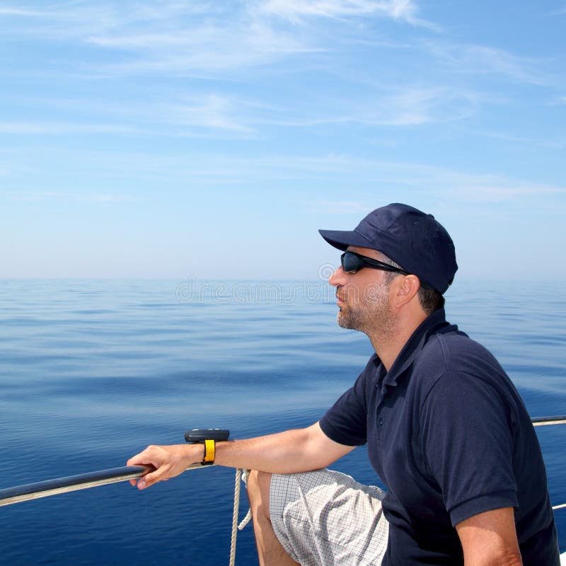 Sailor man sailing boat blue calm ocean water stock photo