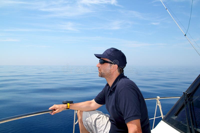 Sailor man sailing boat blue calm ocean water royalty free stock images