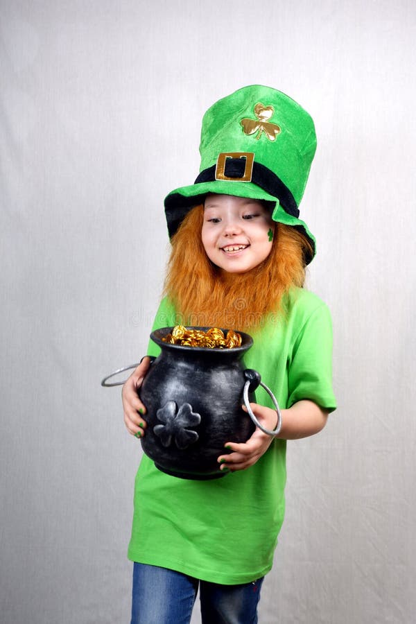 Saint patriarks dag. Lusande liten flicka med dekorativt rött skäggsblad på sin kinka och läskhatt klädd arkivfoton