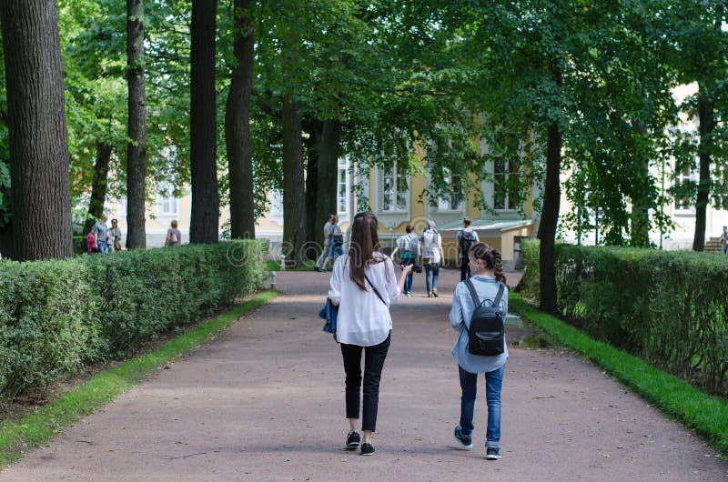 SAINT- PETERSBURG, ROSJA - 20 sierpnia 2016: Peterhof Dwie dziewczyny idące po parku fotografia stock SAINT- PETERSBURG, ROSJA - 20 sierpnia 2016: Peterhof Dwie dziewczyny idące po parku fotografia stock