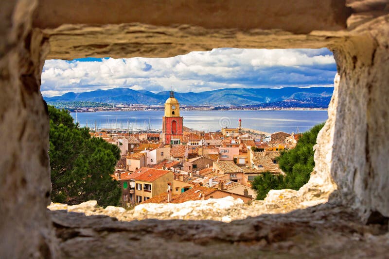 Saint Tropez village church tower and old rooftops view through stone window