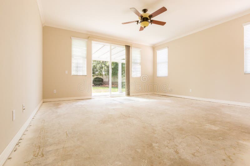 Sala com assoalhos do cimento e fã de teto imagem de stock Sala com assoalhos do cimento e fã de teto imagem de stock