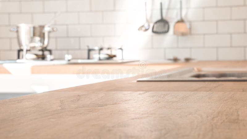 Sala da cozinha e conceito do fundo - parte superior de madeira marrom borrada do contador de cozinha com sala moderna bonita da