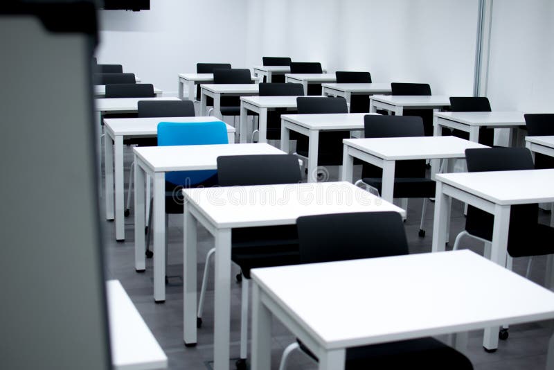Sala de clase con las sillas negras y una silla azul Empleando, vacante o eligiendo concepto foto de archivo Sala de clase con las sillas negras y una silla azul Empleando, vacante o eligiendo concepto foto de archivo
