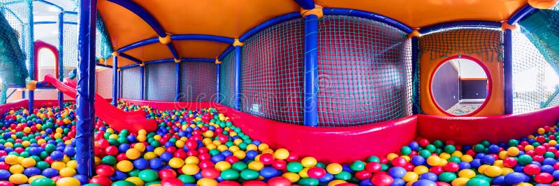 Perto de bolas de plástico coloridas na sala de jogos infantil