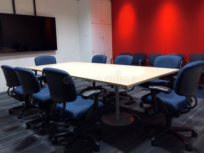 A sala de reunião vazia com a tabela de conferência e as cadeiras ergonômicas da tela usadas como o molde imagem de stock A sala de reunião vazia com a tabela de conferência e as cadeiras ergonômicas da tela usadas como o molde imagem de stock