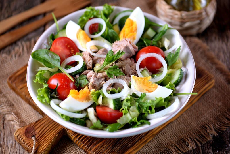 Salad from canned tuna with lettuce, cherry tomatoes, cucumber, onion and boiled egg. Healthy food.