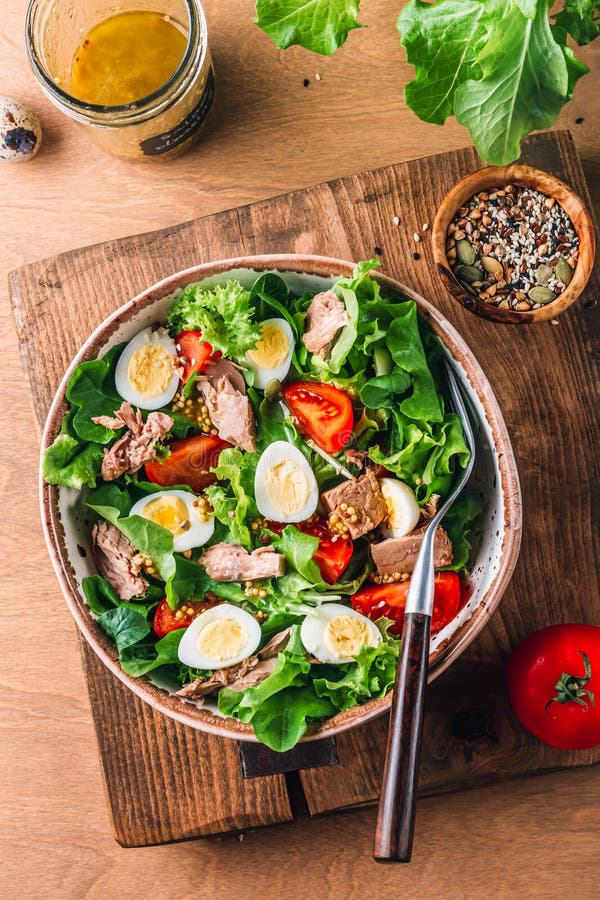 Salad with canned tuna, tomato, quail eggs, lettuce and salad dressing with olive oil, lemon juice and grain mustard. royalty free stock image Salad with canned tuna, tomato, quail eggs, lettuce and salad dressing with olive oil, lemon juice and grain mustard. royalty free stock image
