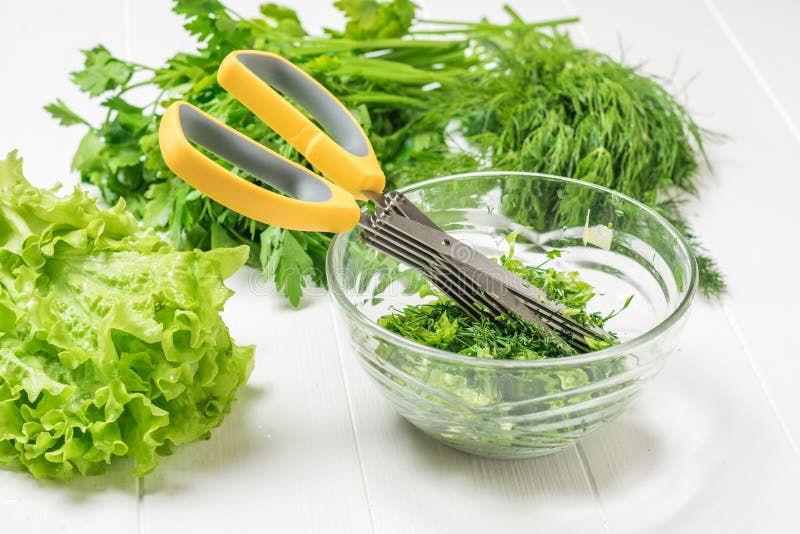 Salad, Dill, Parsley and Scissors in a Glass Bowl. Stock Photo Image