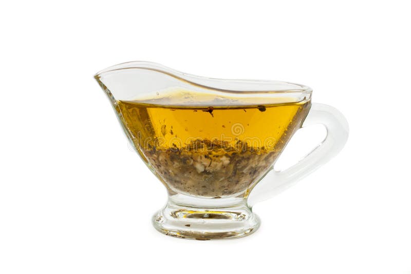 Salad dressing with olive oil in glass sauce boat