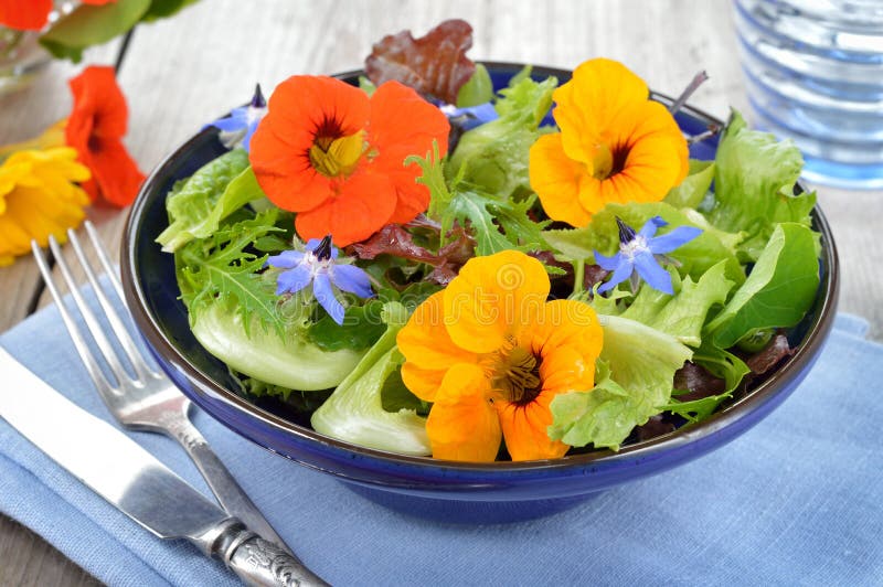 Čerstvé letní salát s jedlými květy lichořeřišnice, brutnák květiny v misce.