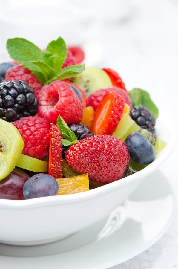 Salad of fresh fruit and berries in a white bowl