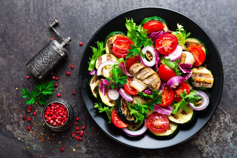 Salad with fresh and grilled vegetables and mushrooms. Vegetable salad with grilled champignons. Vegetable salad on plate stock photography Salad with fresh and grilled vegetables and mushrooms. Vegetable salad with grilled champignons. Vegetable salad on plate stock photography