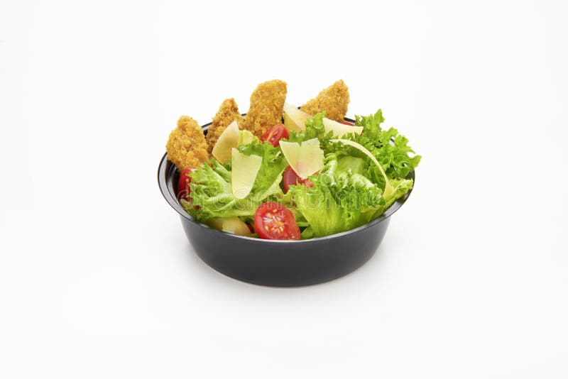 Salad with fried chicken strips and sliced parmesan cheese in a plastic take away bowl on white background